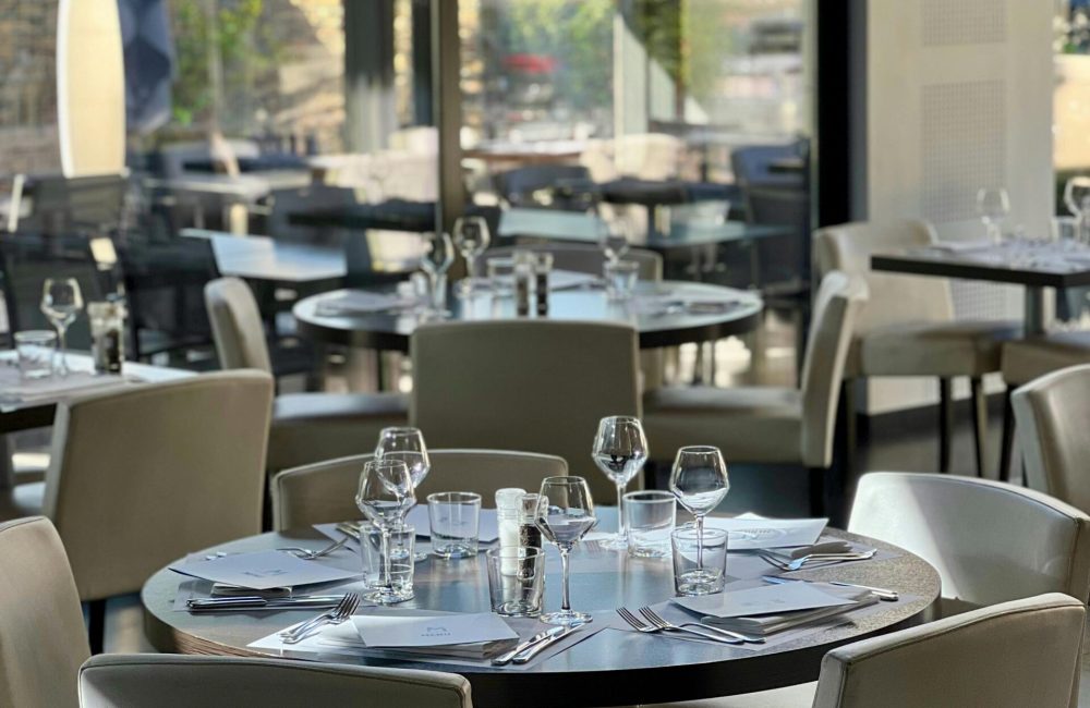 Stylish restaurant interior featuring round tables and modern decor with natural light.
